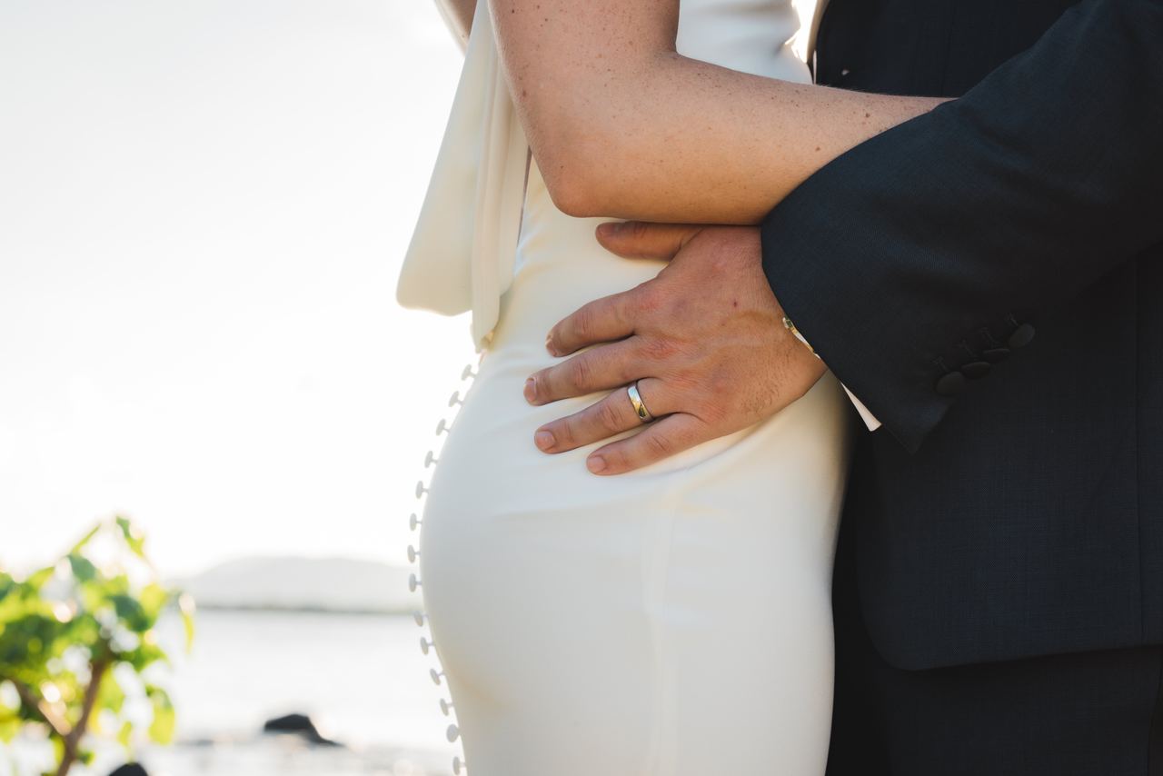 A wedding couple embracing by the water in the Virgin Islands