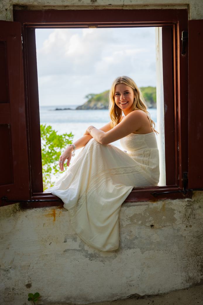 Senior portrait framed in a seaside window