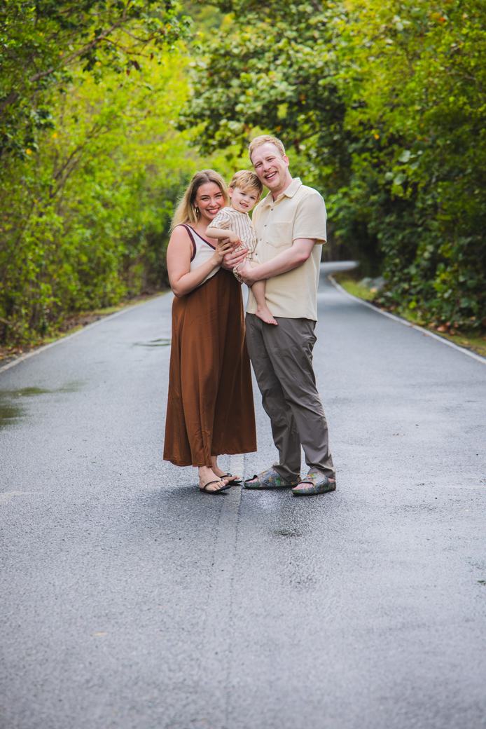 Family of three on a tree-lined island road