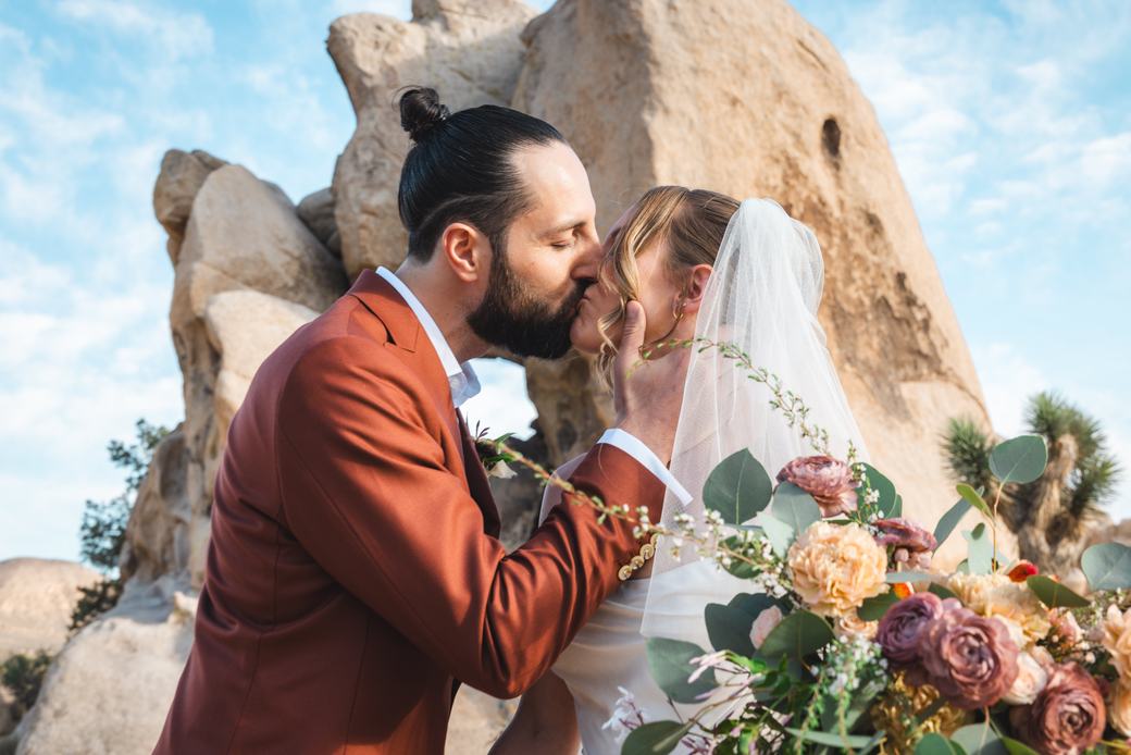 Bride and groom kissing behind the bridal bouquet