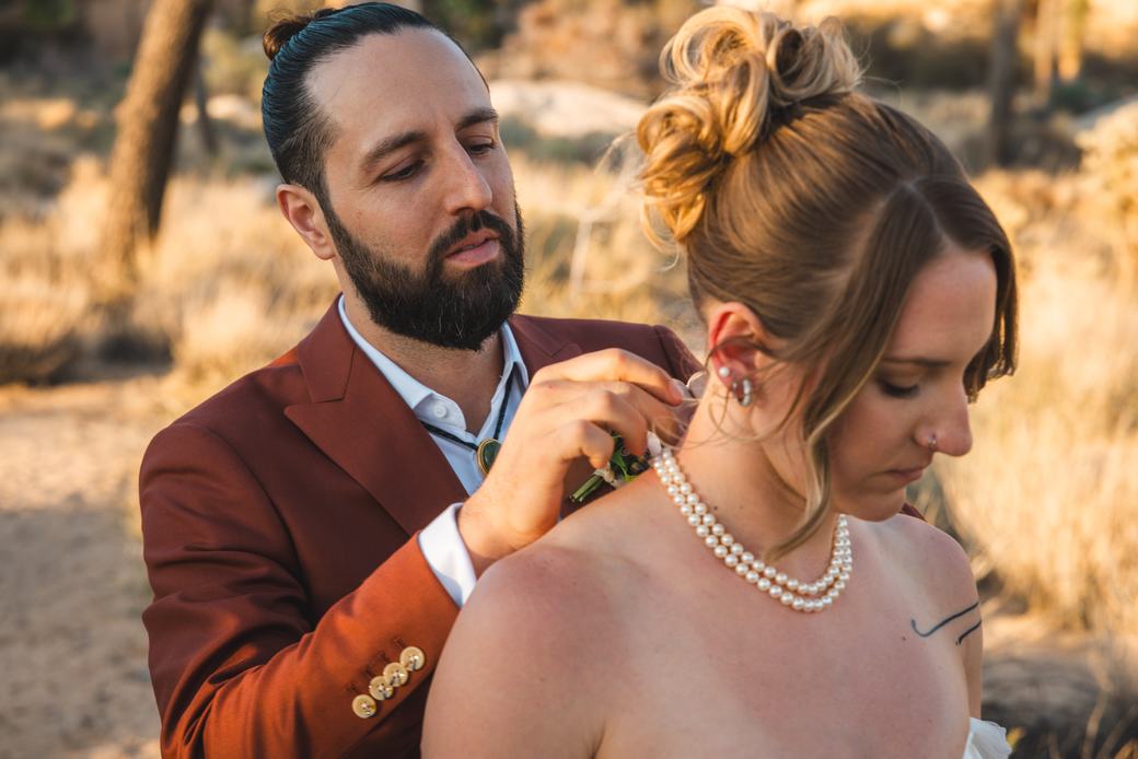 Groom pinning a boutonniere before the ceremony