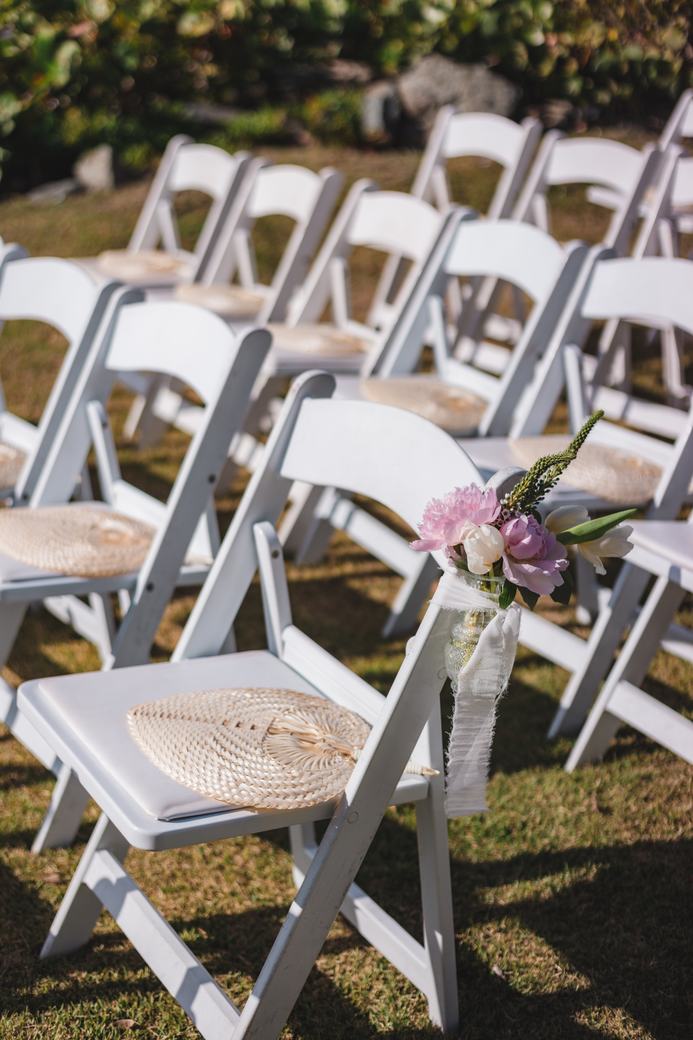 Ceremony seating with woven fans and florals