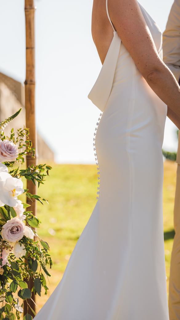 Wedding dress button detail beside the ceremony arch