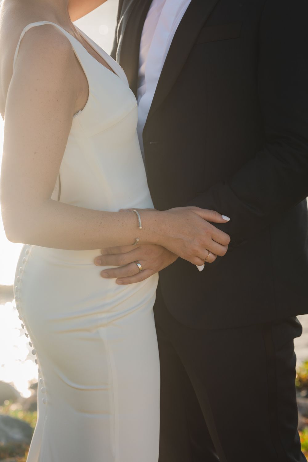 Bride and groom holding hands at golden hour with wedding bands, Virgin Islands