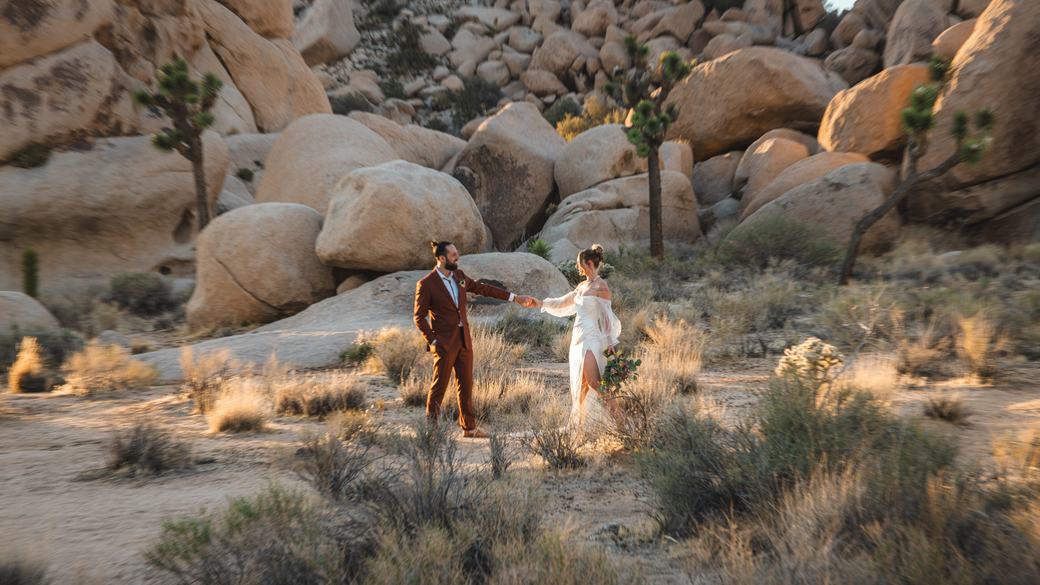 Bride and groom dancing in the desert at golden hour